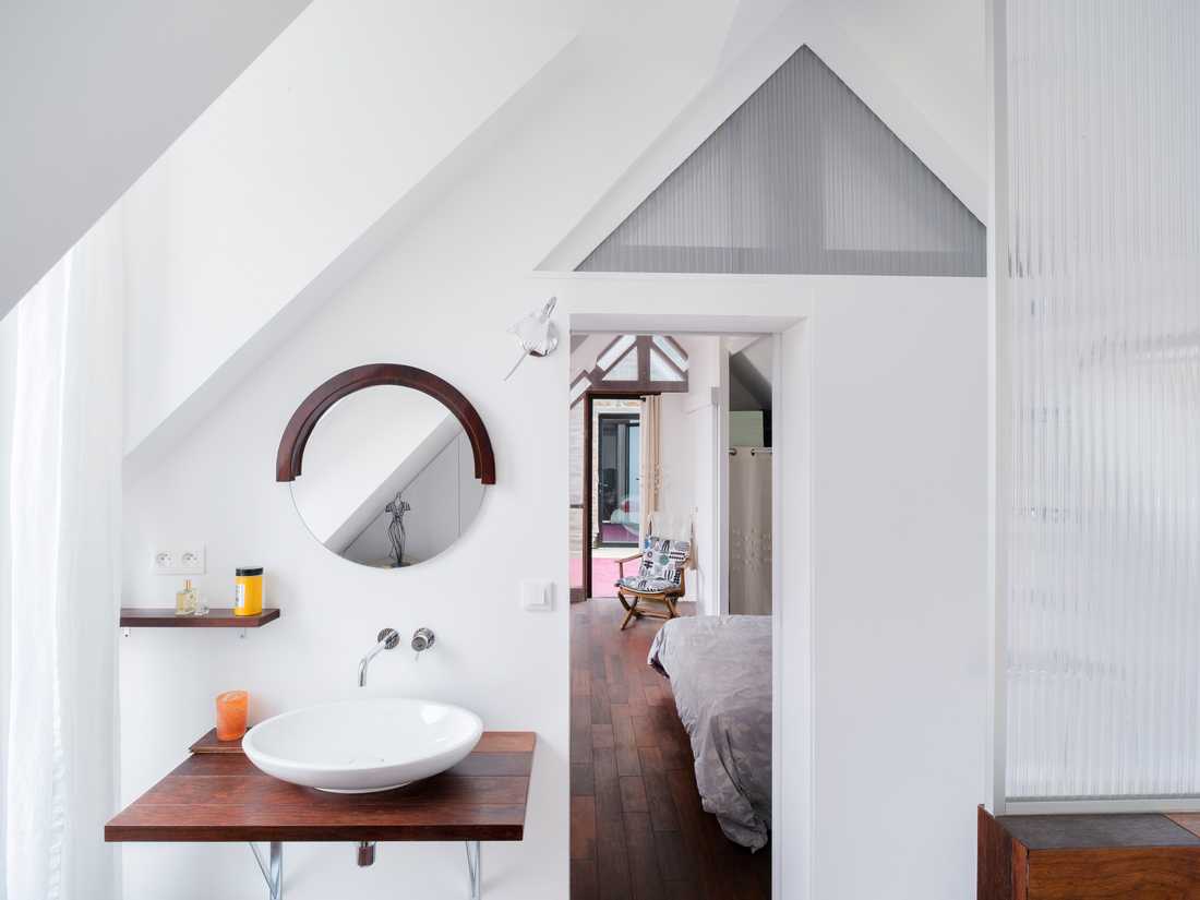 Salle de bain moderne avec lucarne aménagée par un architecte d'intérieur