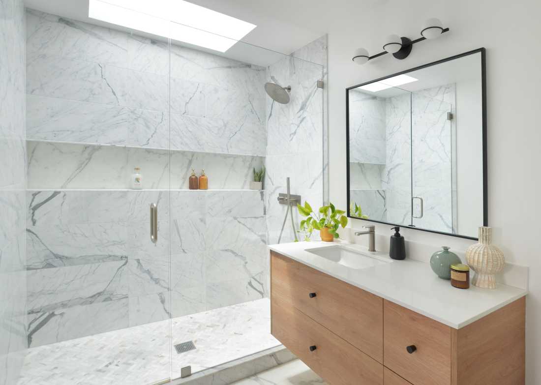 Salle de bain avec revetement mural en marbre et meuble-vasque suspendu